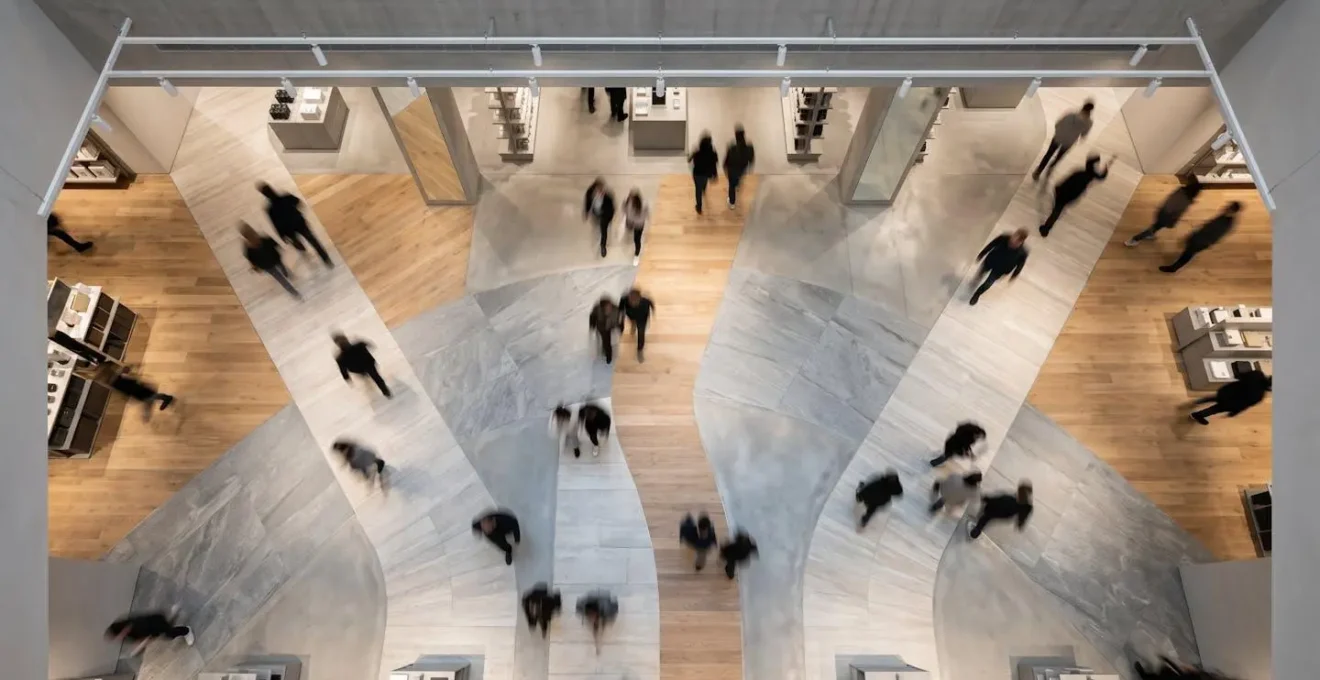 Vue plongeante d'un parcours client guidé par un marquage au sol subtil dans une boutique moderne